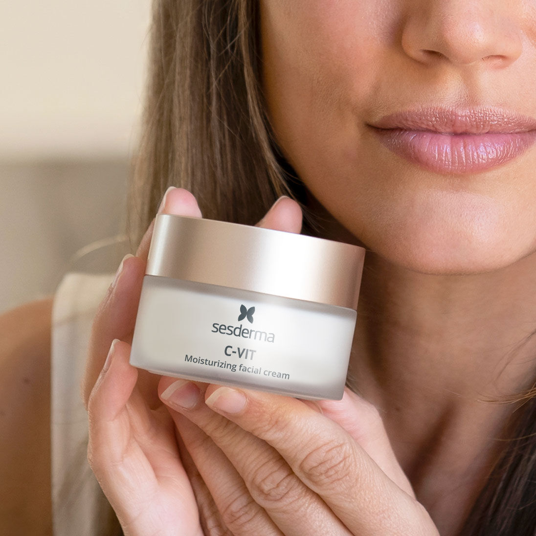 Imagen mujer con producto crema facial c-vit en las manos